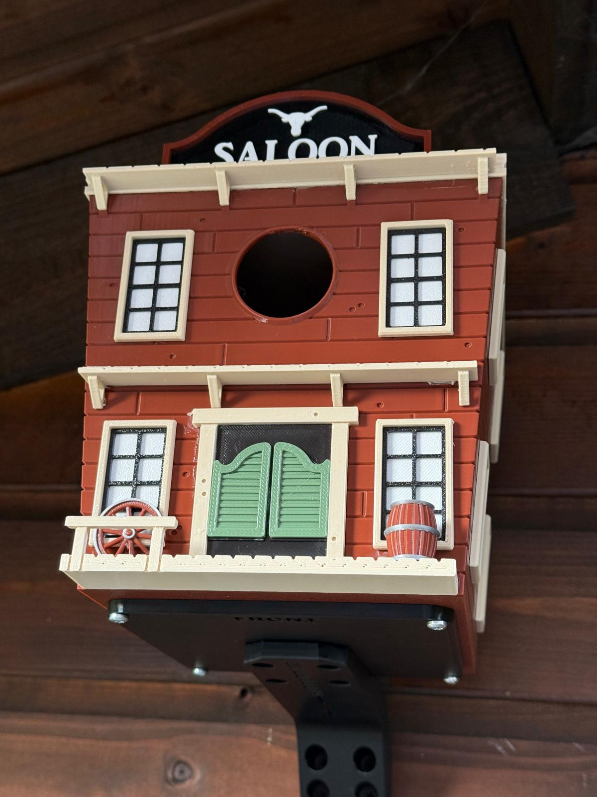 Western Saloon themed 3D printed birdhouse mounted outdoors on garden shed
