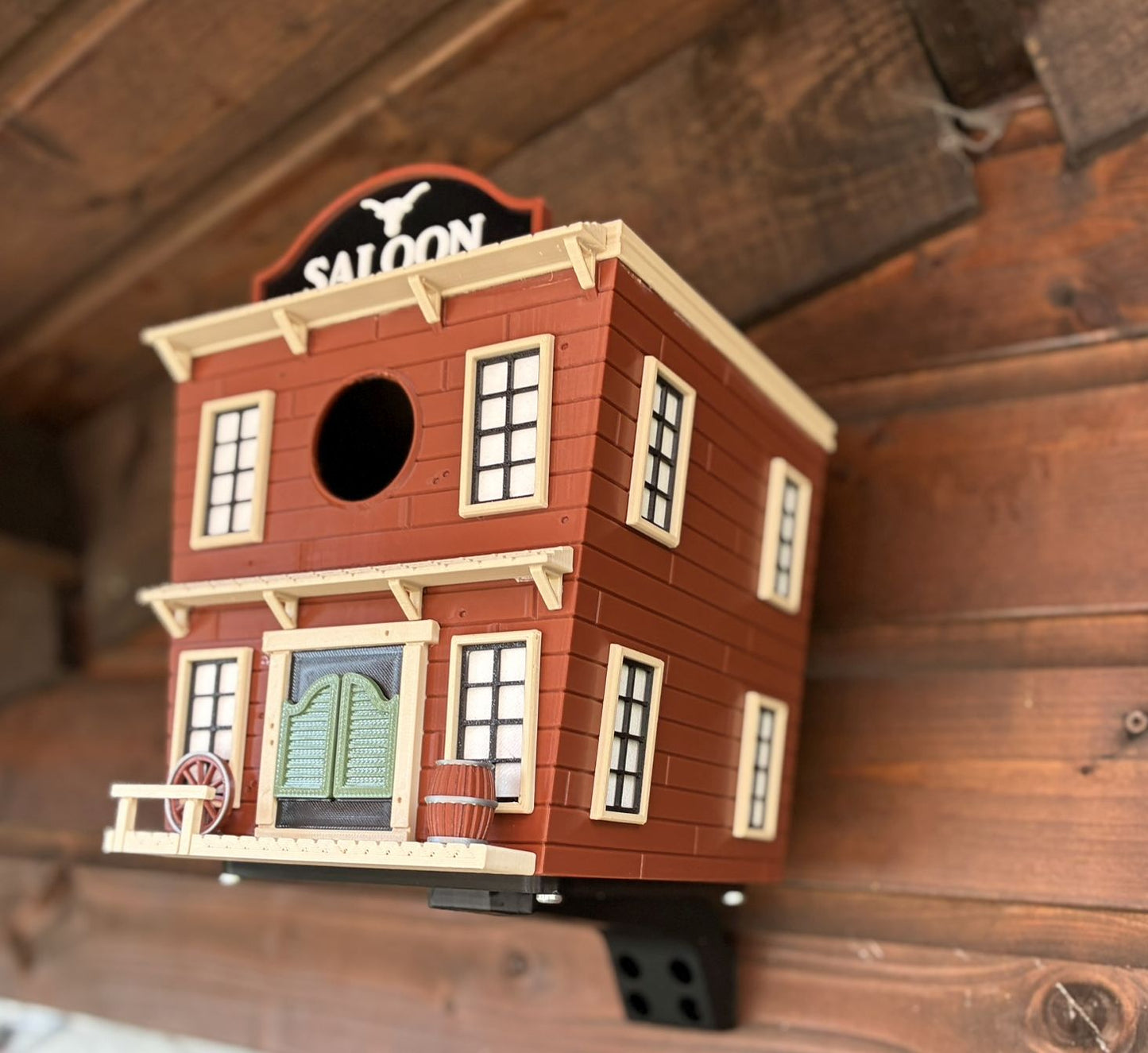 Western Saloon themed 3D printed birdhouse mounted outdoors on garden shed