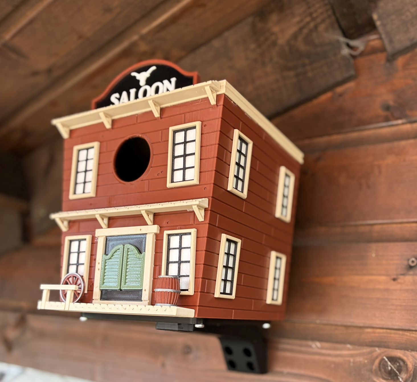 Western Saloon themed 3D printed birdhouse mounted outdoors on garden shed