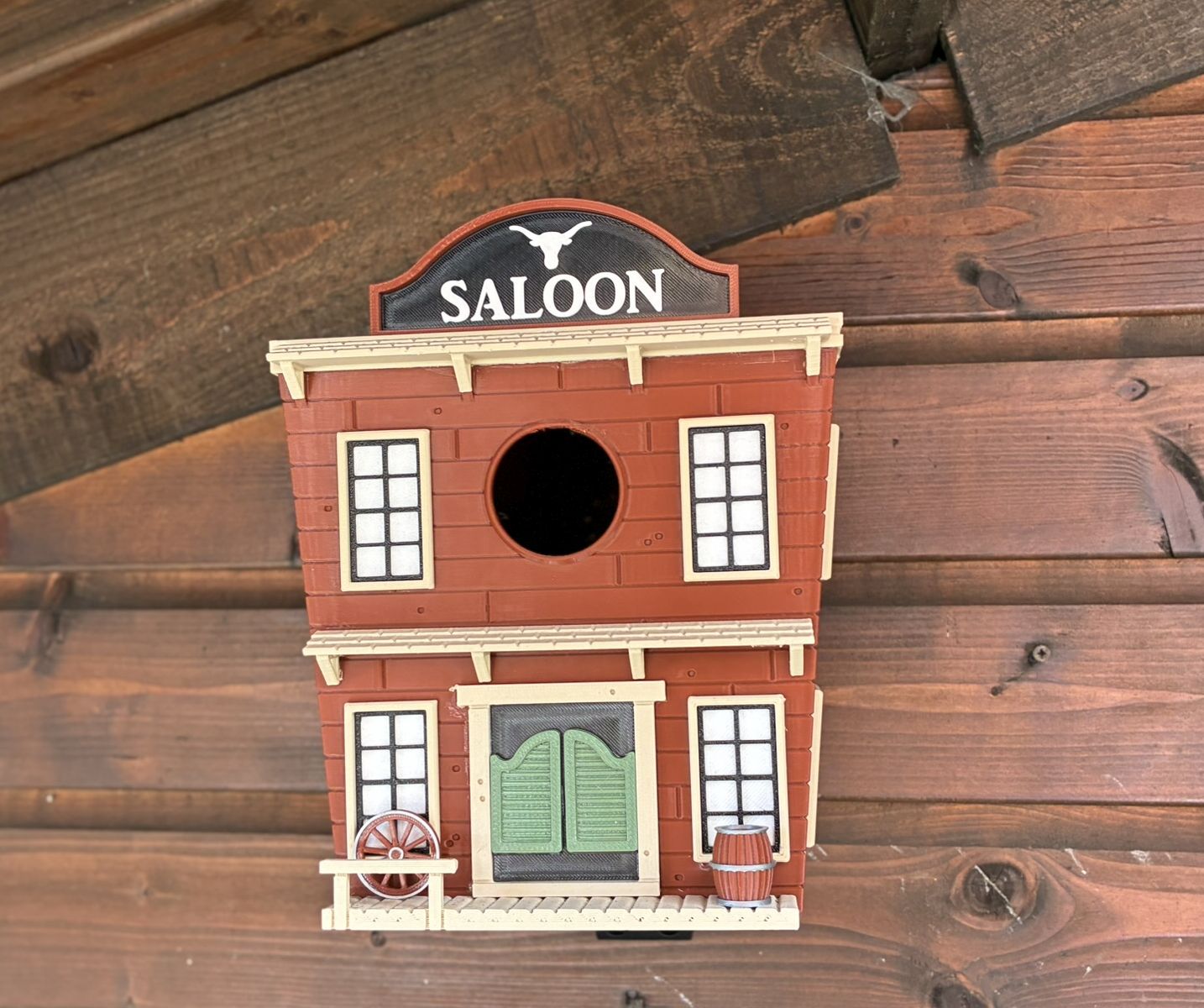 Western Saloon themed 3D printed birdhouse mounted outdoors on garden shed